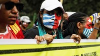 Dalam aksinya mereka menyuarakan tuntutannya sambil membentakan spanduk bertuliskan anti Rasis dan Kapitalisme.