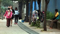 Seorang PKL nampak menggelar lapak di pedestrian kawasan Sudirman, Jakarta, Rabu (28/8/2019).