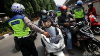 Polisi menyetop pengendara sepeda motor untuk diperiksa kelengkapan suratnya.