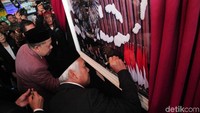 Agus Hermanto dan Fahri Hamzah membubuhkan tanda tangan di foto master yang dipamerkan.