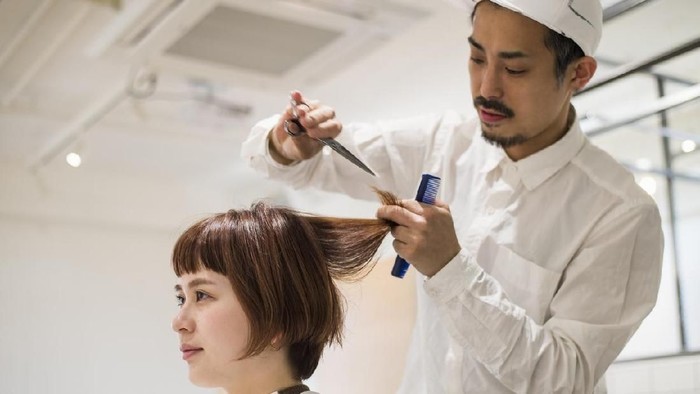 Young woman at a hair salon and cutting hair.