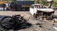 Tampak sebuah kendaraan berupa sepeda motor dan mobil hangus terbakar.
