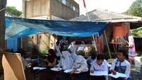 Sebanyak 65 siswa kelas 7, 8, dan 9 SMP Terbuka belajar di tempat belajar beratapkan terpal di halaman depan dan belakang rumah warga karena tak memiliki bangunan sekolah sejak tahun 2011.