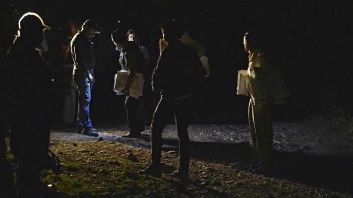 Police and forensic personnel holding white bags for corpses stand by an unmarked grave in 2014 in Guerrero state, Mexico -- a country that has suffered a wave of violence since launching the so-called drug war (AFP Photo/YURI CORTEZ)