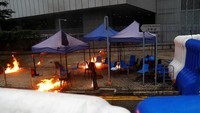 Ketegangan meningkat menjelang sore hari, saat demonstran garis keras mulai melempari polisi dengan batu, melakukan pembakaran dan mengarahkan sinar laser ke polisi yang berjaga di balik barikade yang dipasang di luar Gedung Parlemen Hong Kong, atau yang disebut sebagai Dewan Legislatif (LegCo). Kai Pfaffenbach/Reuters.