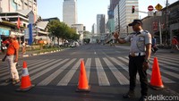 Sejumlah petugas nampak bersiaga di kawasan Jalan Thamrin, Jakarta, untuk menutup sementara ruas jalan tersebut selama gelaran acara Jakarta Muharram Festival 2019 berlangsung di kawasan Bundaran HI, Sabtu (31/8/2019).