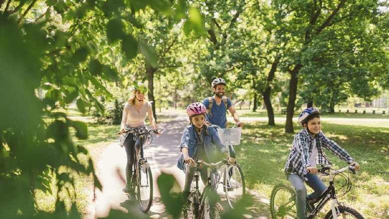 Ilustrasi keluarga bersepeda Family riding bicycle in the public park together. Cycling and enjoying the sunny day