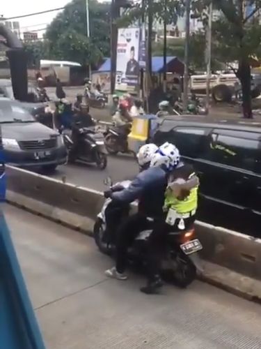 Polantas memberi isyarat agar si pemotor tidak lagi lawan arah untuk berusaha kabur