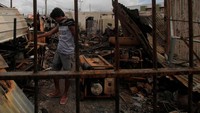 Seorang Warga mencari dari sisa bangunan yang terbakar di Entrop, Kota Jayapura.