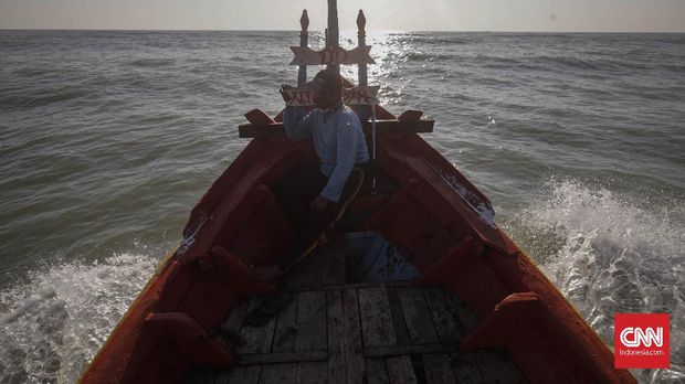 Nelayan yang ikut bertugas mengumpulkan tumpahan minyak mentah yang tercecer di Laut Utara Karawang.