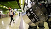 Petugas polisi antihuru-hara mengenakan peralatan lengkap bersiaga di area sekitar stasiun MTR di Kota Hong Kong. Anushree Fadnavis/Reuters.