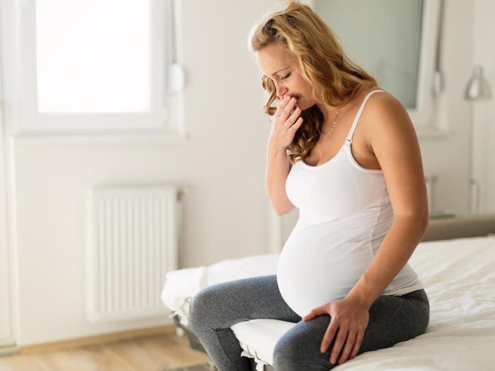 Pregnant woman suffering with nausea in morning