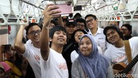 Rian juga berswafoto dengan penumpang KRL.