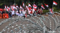 Aksi ini dilakukan di depan kawat berduri yang dipasang di depan Istana.