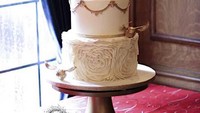 Dengan dominasi warna putih, kue pernikahan ini dibuat dengan tema pesta natal yang klasik. Ada sentuhan romantis dengan desain bunga pada tingkatan bawah kue. Foto: Istimewa