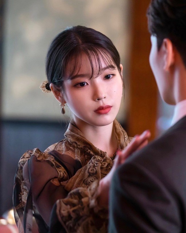 Salah satu hal yang dipopulerkannya dalam serial ini adalah poni anak rambut. Gaya poni IU dibuat sangat tipis sehingga mirip anak rambut yang tumbuh panjang. Model poni tersebut menjadikannya penampilan wajahnya semakin fresh. Foto: Instagram/Pinterest