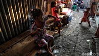 Sejumlah anak bermain di depan rumah yang dikepung oleh tumpukan sampah.