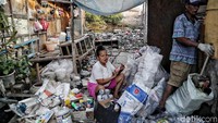 Dua orang warga mengais botol-botol plastik yang masih bisa dijual.