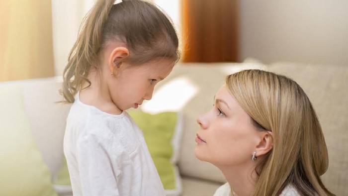Beautiful mother is comforting her sad little daughter at home. Family relationships.