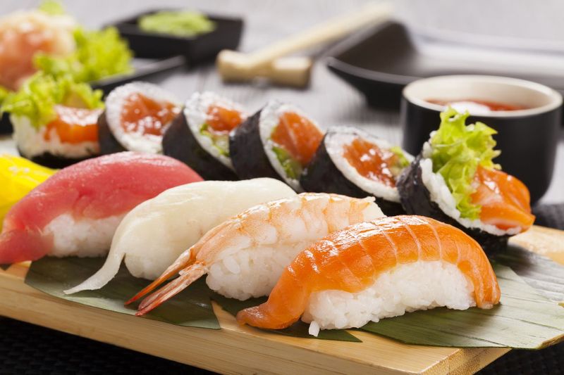 The composition of nigiri sushi with tuna, salmon, shrimp, butterfish on rice