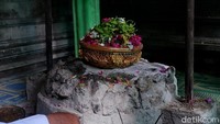 Batu bundar berukuran diameter 45 cm di dalam petilasan. Ada dua payung yang diletakkan menutupi batu tersebut. (Ardian Fanani/detikcom)