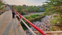 Sejumlah pejalan kaki maupun pengendara yang melintas di jembatan sekitar Kali Jambe harus menutup hidung. (Isal Mawardi/detikcom)