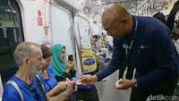 Ini momen saat Dirut MRT William Sabandar membagikan pin kepada para penumpang.