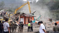 Warga yang berdemo membawa spanduk juga bendera Merah Putih. Massa juga membakar ban yang diletakkan berjejer di pinggir jalan.