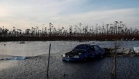 Sebuah mobil nampak terendam banjir usai diterjang Badai Dorian di Kepulauan Bahama. Marco Bello/Reuters.