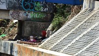 Seorang ibu bersama anaknya bahkan tertidur di pinggir kali.
