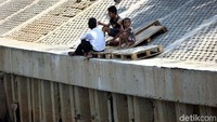 Sejumlah bermain di bantaran kali yang telah diturap di sepanjang Kali Grogol, Palmerah Barat, Jakarta, Kamis (05/09/2019).