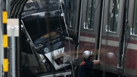 Truk besar yang bertabrakan dengan kereta terjepit di antara gerbong kereta dan sebuah dinding. Si pengemudi truk yang berusia 60-an tahun, kini dalam kondisi kritis di rumah sakit setempat Foto: REUTERS/Issei Kato