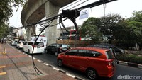 Kabel tersebut tampak memotong jalur trotoar.