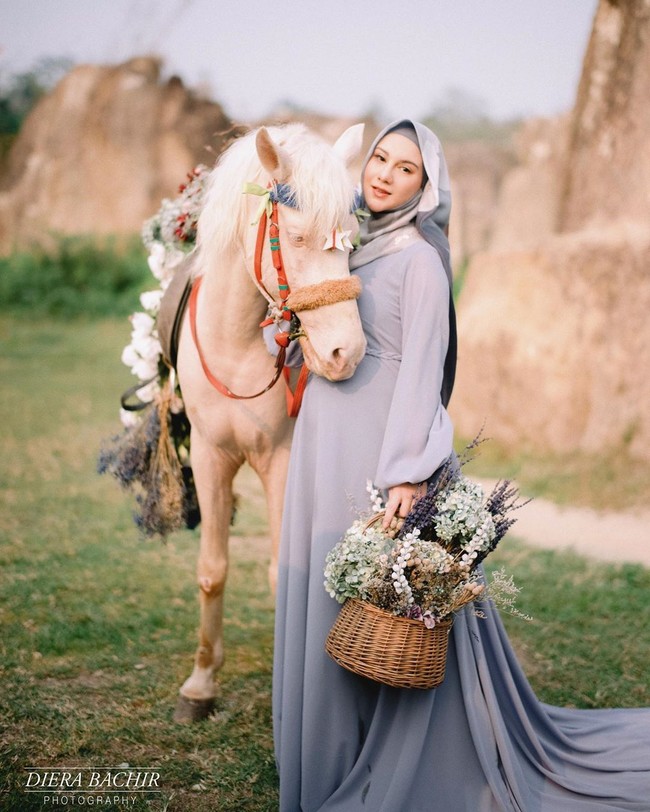 Kehadiran kuda putih yang dihiasi rangkaian bunga indah semakin memperkuat tema negeri dongeng ala Irish Bella dan Ammar Zoni. Pemotretan ini dilakukan di Taman Wisata Tebing Koja yang terletak di Cirendeu, Tangerang. Foto: instagram @dierabachir