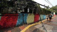 Keberadaan kabel yang semrawut menggangu pejalan kaki yang melewati trotoar.