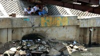 Meski bermain di area berbahaya mereka nampak santai dan menikmati dengan sambil duduk di atas turap.