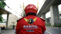 Helm dan jaket Gaspol berwarna merah mencolok.