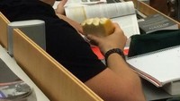 Perut lapar kala mendengar penjelasan dosen, mahasiswa ini diam-diam menyantap makanan yang dibawanya. Foto: Istimewa