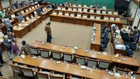 Nampak Sri Mulyani sedang berdiri sambil menaruh tangannya di atas kursi.