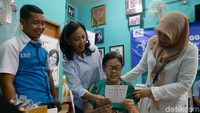 Corporate Communications and Social Responsibilities Division Head Lydia Astriningworo dan Customer Service & Operation Deputy Director Irma Gusyani Taib berbincang dengan seorang warga yang sedang mencoba kacamata. 