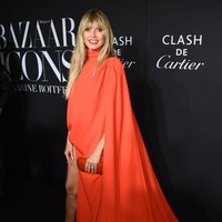 Heidi menebar pesona dalam balutan gaun merah bervolume dengan ekor yang menjuntai hingga menyapu lantai. Gaun tersebut juga hadir dengan belahan tinggi pada bagian rok sehingga mempertegas keseksian sang model. (Foto: Getty Images)