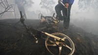 Relawan pemadam kebakaran menyirami motor yang ikut terbakar saat api membakar lahan gambut di Desa Pengayuan, Kecamatan Liang Anggang, Banjarbaru, Kalimantan Selatan, Jumat (6/9/2019). ANTARA FOTO/Bayu Pratama S.