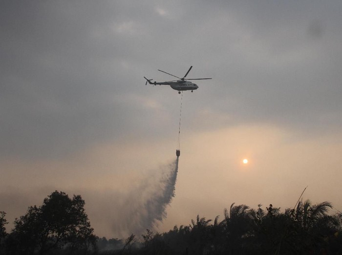 Helikopter milik Badan Nasional Penanggulangan Bencana (BNPB) melakukan water bombing pada kebakaran lahan gambut di Desa Pengayuan, Kecamatan Liang Anggang, Banjarbaru, Kalimantan Selatan, Jumat (6/9/2019). Ratusan hektar lahan gambut di kawasan Liang Anggang terbakar hingga mendekati permukiman penduduk di wilayah setempat.ANTARA FOTO/Bayu Pratama S/pd.