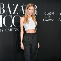 Martha Hunt memamerkan perut ratanya dengan crop-top dan celana high-waist hitam. Tidak ketinggalan high-knee boots hitam turut menyempurnakan gayanya. (Foto: Getty Images)