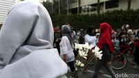 Para pegawai KPK melakukan long march dari lokasi car free day ke gedung Merah Putih KPK seusai bagi-bagi bunga.