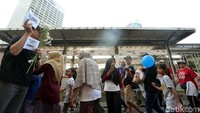 Para pegawai KPK membagikan bunga kepada masyarakat yang datang ke acara Car Free Day (CFD).