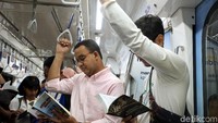 Anies membaca buku bersama para penumpang MRT dari Stasiun MRT Bundaran HI menuju Stasiun Lebak Bulus.