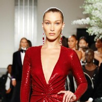 Bella Hadid mendapat mandat untuk menampilkan gaun merah sequined nan berkilauan. Gaun tersebut hadir dengan gaya plunging-neck atau berbelahan dada rendah sehingga sukses mengakomodasi keseksian adik Gigi Hadid ini. (Foto: Getty Images)