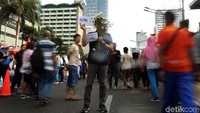 Bagi-bagi bunga dilakukan di tengah-tengah lalu-lalang warga yang beraktivitas di acara Car Free Day.