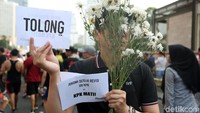 Mereka juga membawa selebaran kertas bertulisan Tolong dan Jokowi Setuju Revisi UU KPK=KPK Mati. 